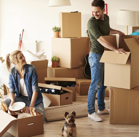 Young couple in new apartment with small dog